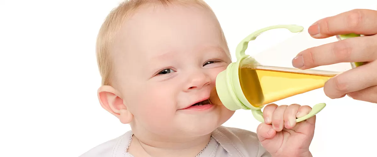 малыш пьет сок из бутылочки